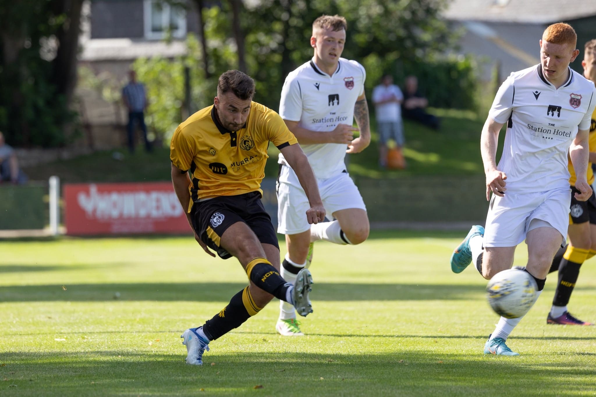 Nairn County Football Club player wearing yellow and black football strip in game of football