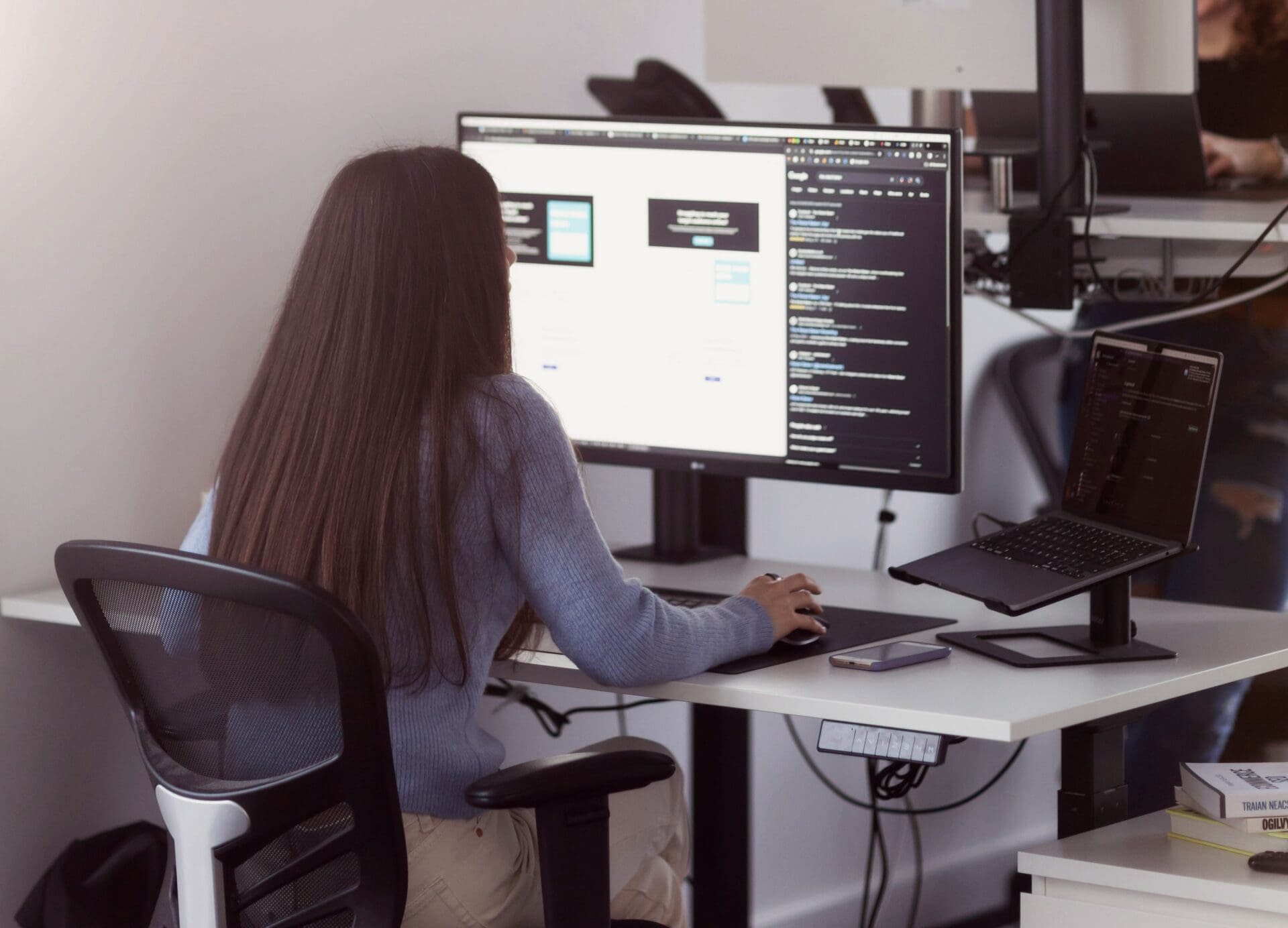 Woman with long dark hair looking at a computer screen
